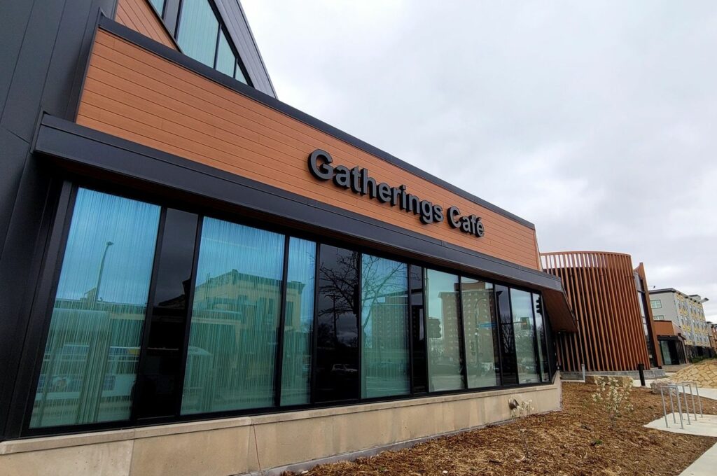 Gatherings Cafe seen from Franklin Avenue. The building has big windows and brown trim. A sign reads Gatherings Cafe.