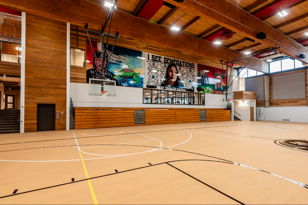 MAIC gym with a basketball hoop and bleachers.