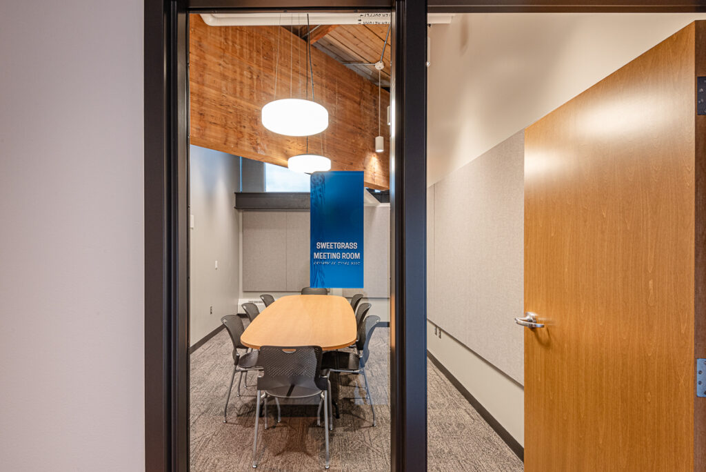 A meeting room with a large oval table and chairs around it.