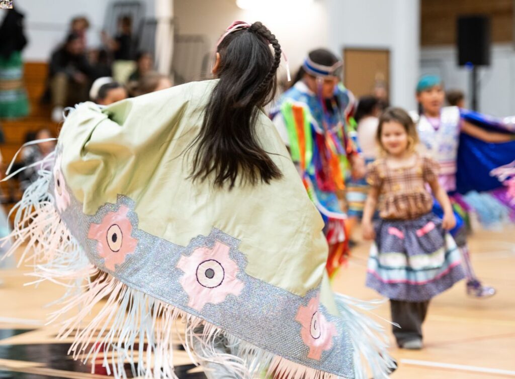 A young girl dancing in her shawl.